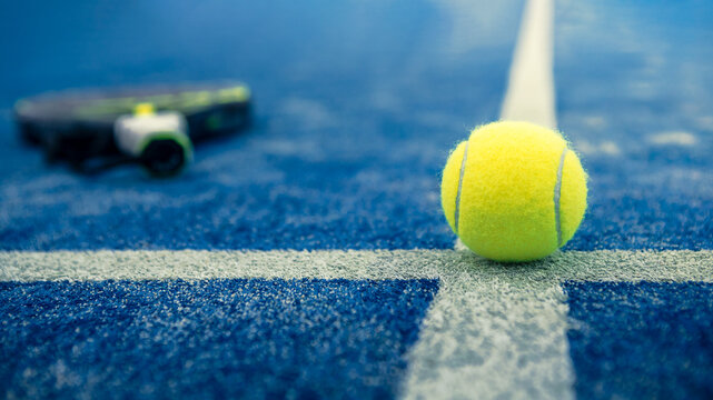 Padel Ball und Schläger auf blauem Court